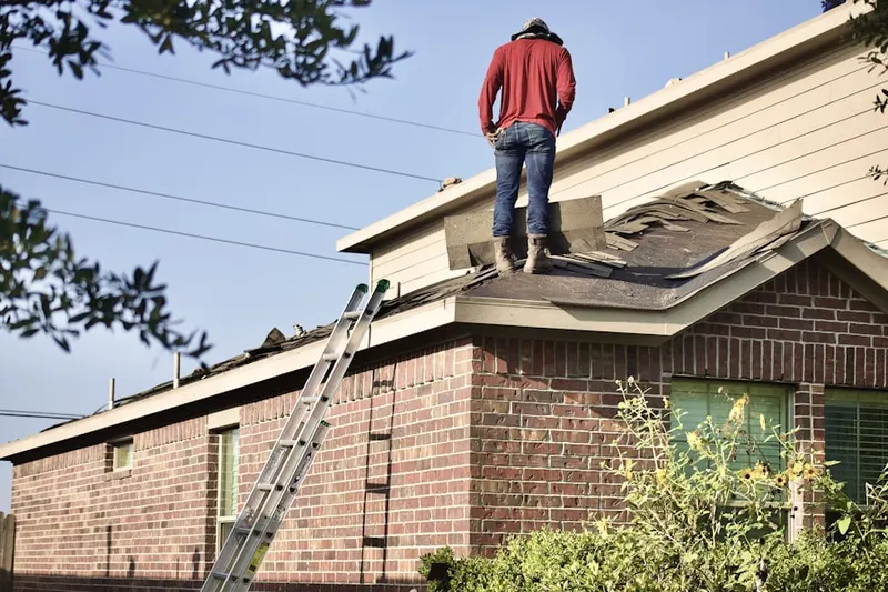 Professional roofer working on a residential roof in Alvan